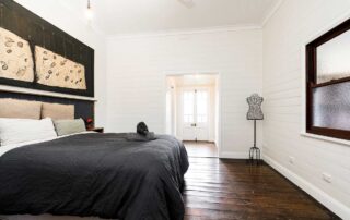 Cromwell Farmhouse bedroom with a black bed and a white wall