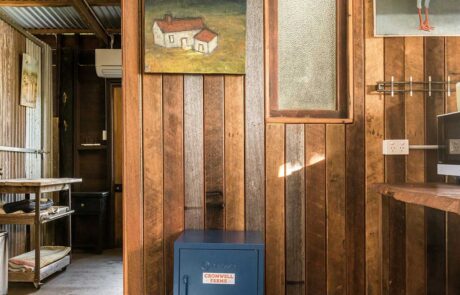 Middle Shed kitchen with dark timber walls, a painting and a blue locker box with Cromwell Farms on it