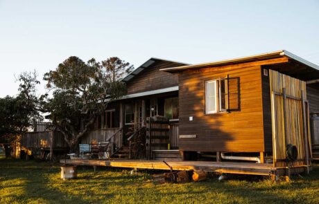 A wooden house with a fire pit and grass field called Middle Shed
